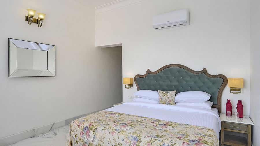 Fateh Vilas Udaipur - interior view of the Family Suite with a king size bed with a floral blanket
