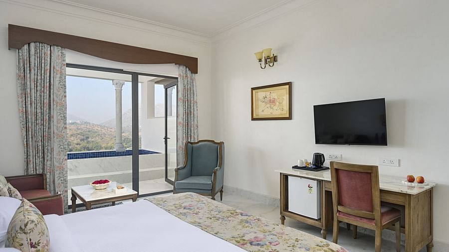 Fateh Vilas Udaipur - interior view of the Plunge Pool Suite featuring a television a work desk a bed balcony and a coffee table