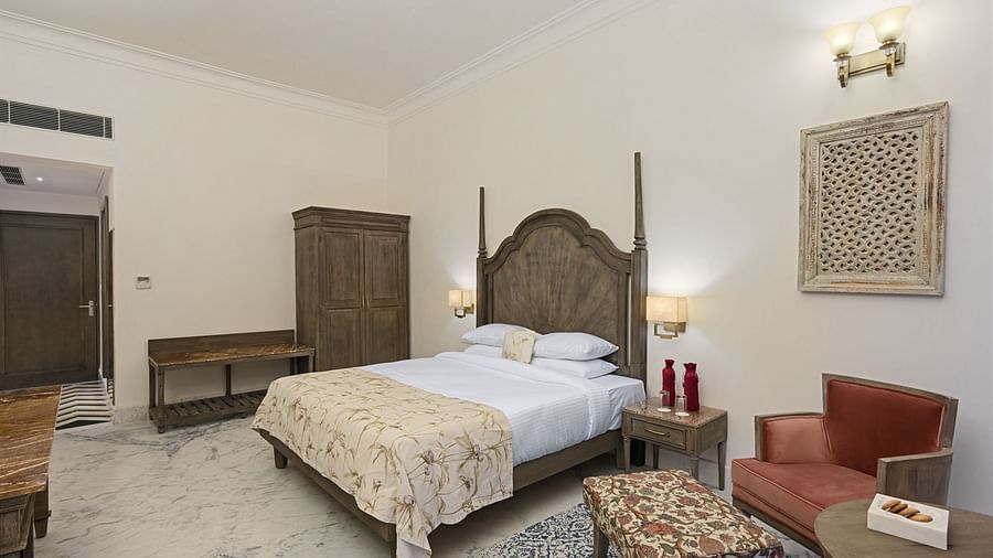 Fateh Vilas Udaipur - interior view of the Renaissance Room featuring a bed a wardrobe a coffee table and white decor