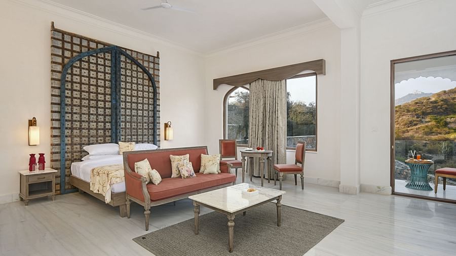 Fateh Vilas Udaipur - interior view of the suite featuring a king size bed a sofa and a coffee table in the balcony