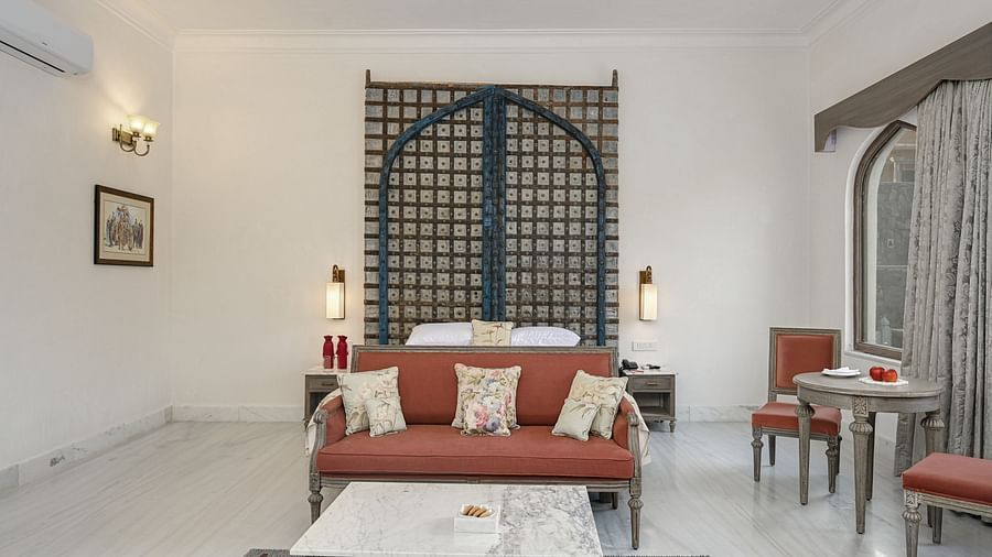 Fateh Vilas Udaipur - interior view of the suite featuring a king size bed numerous seating options and an air-conditioner