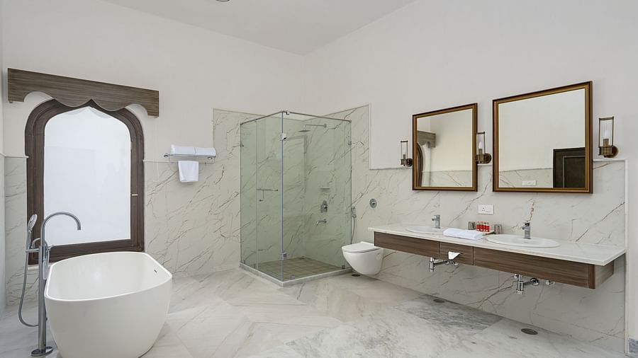 Fateh Vilas Udaipur - interior view of the suite's bathroom featuring a bathtub a shower area two wash basins and two mirrors