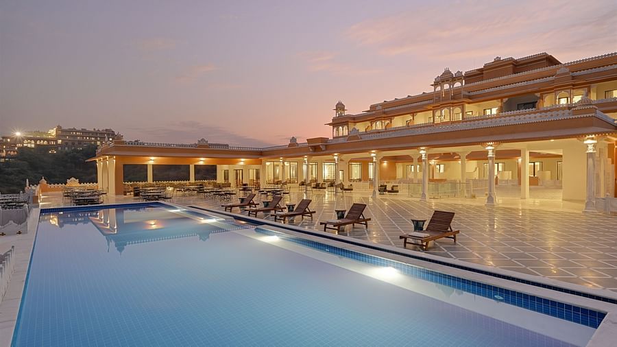 Fateh Vilas Udaipur - view of the property's swimming pool illuminated with lights underwater