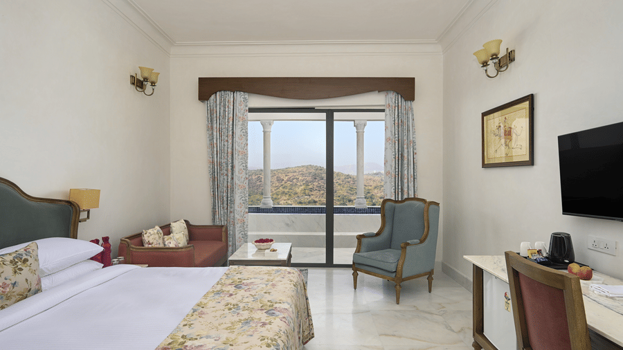 A room at Fateh Vilas, Udaipur, of the Plunge Pool Suite featuring a bed a television a coffee table sofa and a balcony.