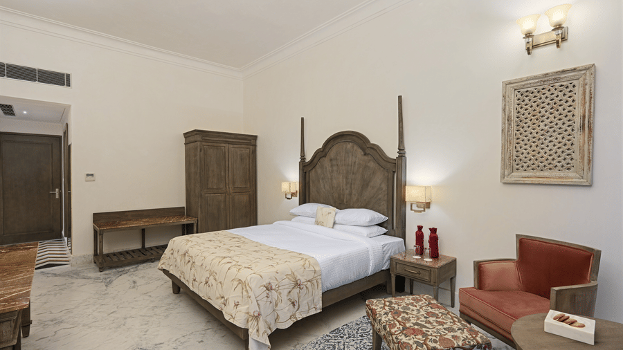 Renaissance Room at Fateh Vilas Udaipur, featuring a bed, a wardrobe, and a coffee table for a relaxing stay in Udaipur