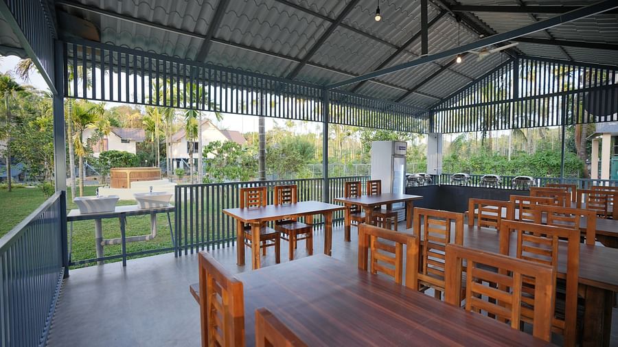 Dining area with tables and chairs with a view of the lush greenery at Feel Free Retreat, Wayanad