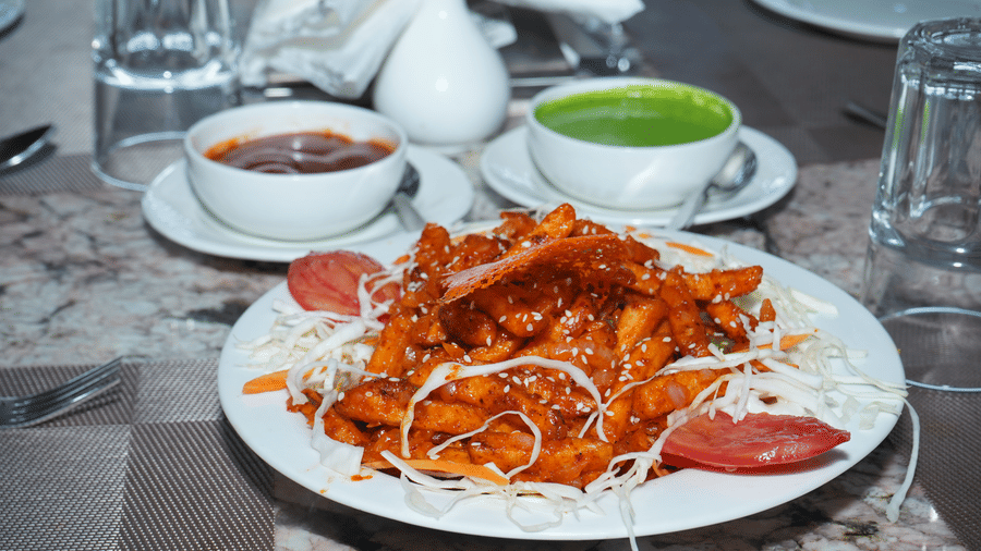 Close-up shot of a restaurant meal featuring a platter of garnished starter food, soup bowls, and water glasses on a dining table - Five Elements Hotels, Corbett Crown Resort, Jim Corbett