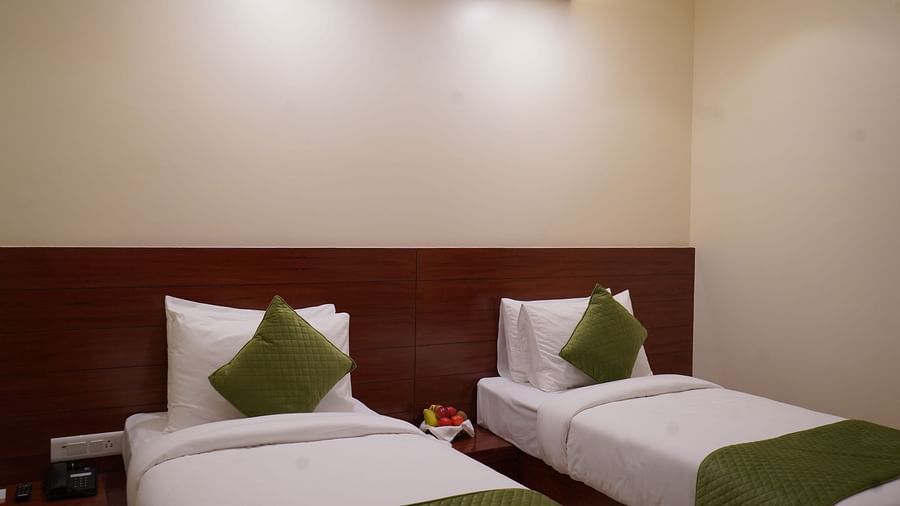An image of a similar looking bed placed next to each other and between them there is a bedside table with fruit basket - Five Elements Hotel, Jodhpur