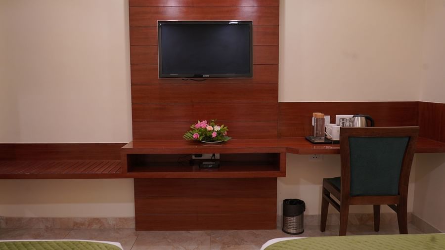 An image of a flat TV screen, next to it there is a work desk and chair, and a tea and coffee maker at Five Elements Hotel, Jodhpur