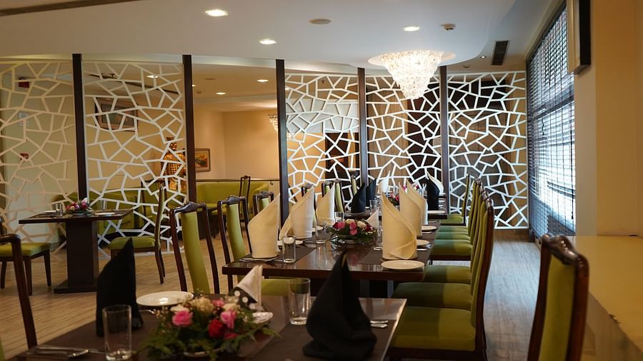 An image of a restaurant featuring  chairs, tables, and a chandelier light on top - Five Elements Hotels North Avenue, Delhi