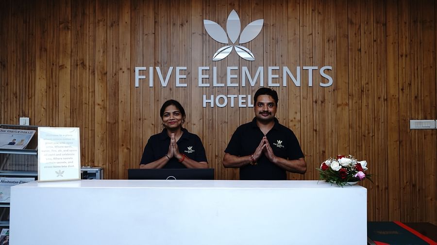 An image of a reception lobby where two people are standing behind the desk to welcome guests at Five Elements Hotels North Avenue, Delhi