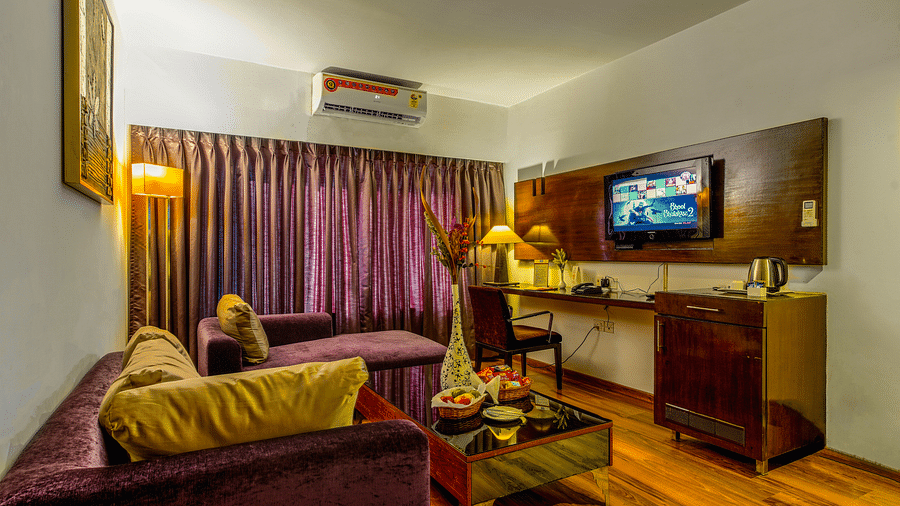 The living area of the suite is furnished with sofas and a TV - GIS Select