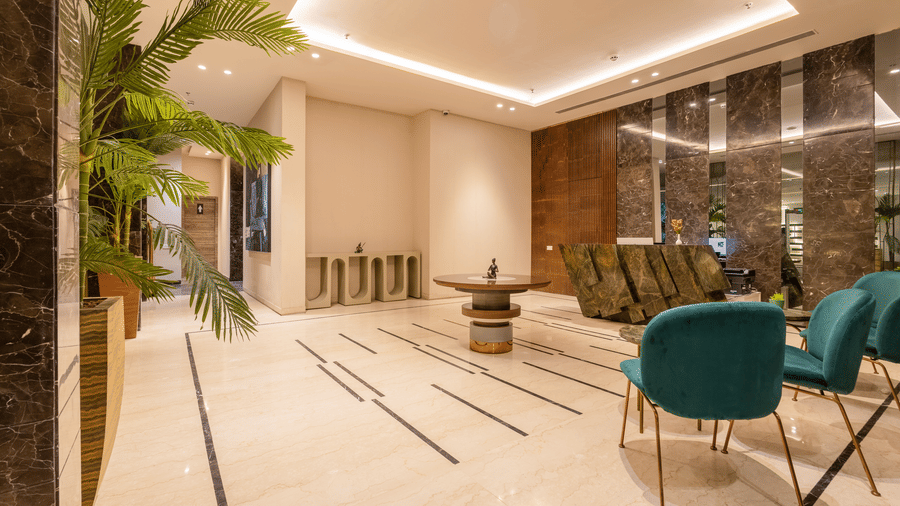 Spacious indoor lobby at Golden Tulip - Sector 80, Gurugram featuring tiled floors, seating arrangements, and marble accents.
