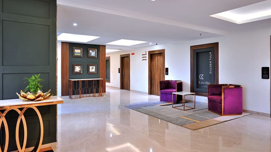 An image of a corridor at Golden Tulip, Agra with two cosy upholstered placed in front of a coffee table - Golden Tulip, Agra