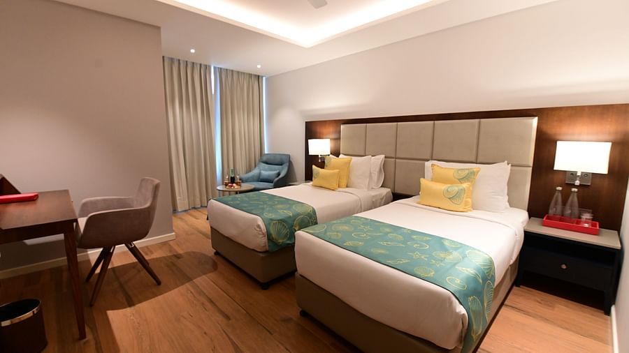 A room at Golden Tulip Vagator, Goa with twin beds and a work desk and chair