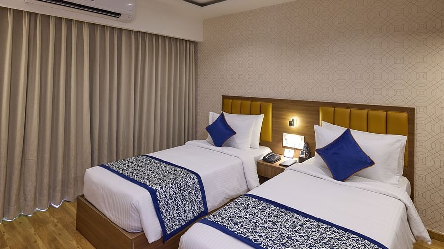 A stylish hotel room with twin beds and floor-to-ceiling curtains - Grand Continent, Brookefield