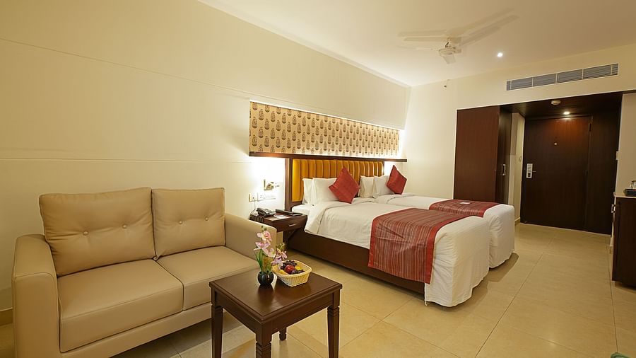 Deluxe room with twin beds and a sofa at Grand Continent, Secunderabad