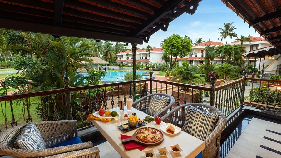 outdoor dining space overlooking the swimming pool at chutney - restaurant near arossim beach in goa