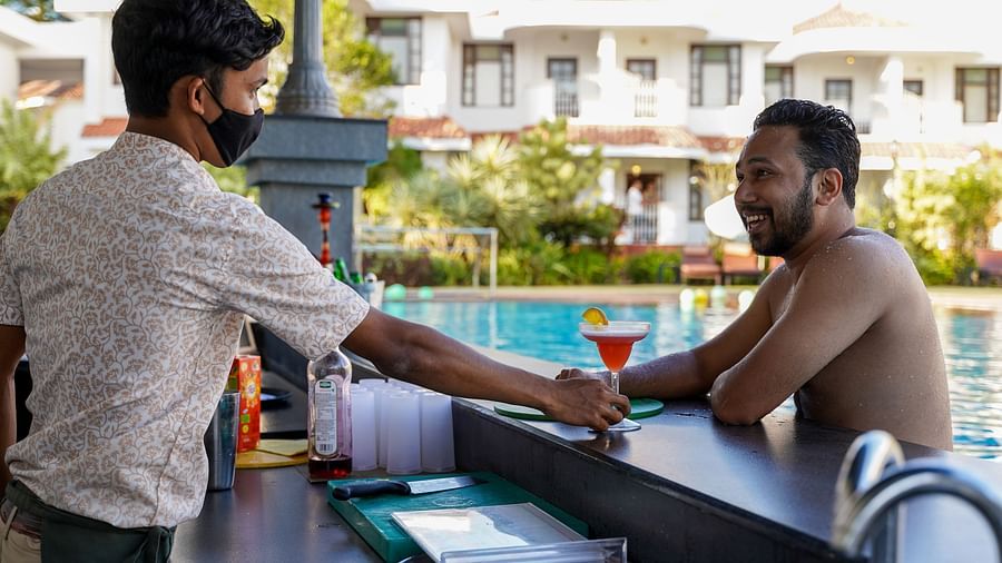bartender serving the guest a drink at pool sunken bar in goa