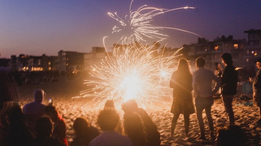 people playing with fireworks on a beach - Heritage Village Resort & Spa, Goa