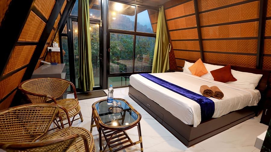 Luxurious Tower Room at Holistic Eco-Resort, Kannur featuring comfortable bedding, modern amenities, wooden interiors and eco-friendly design elements for a peaceful stay.