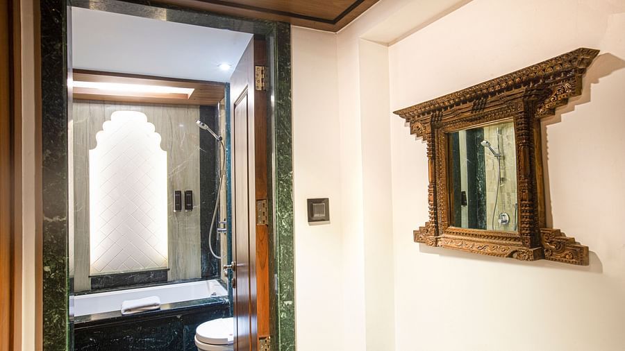 A Rajasthani-themed bathroom adorned with marble and wooden furnishings, reflecting traditional design elements and a warm atmosphere.