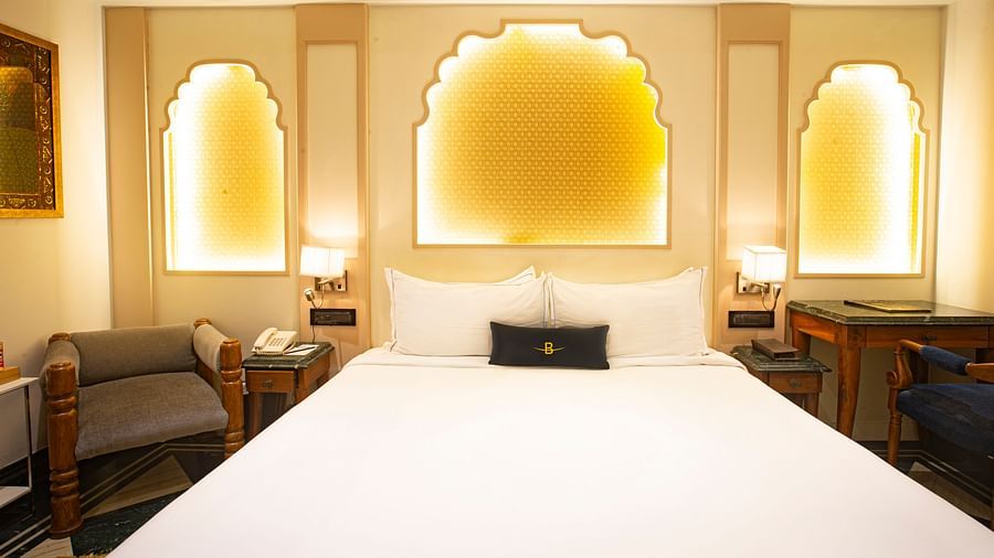 A front view of a Rajasthani-themed bedroom, featuring decorative lighting and a comfy bed, creating a warm and inviting atmosphere.