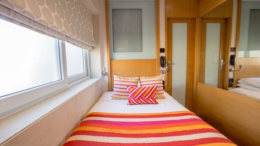 room with single bed and wooden furnishing at hotel bawa continental
