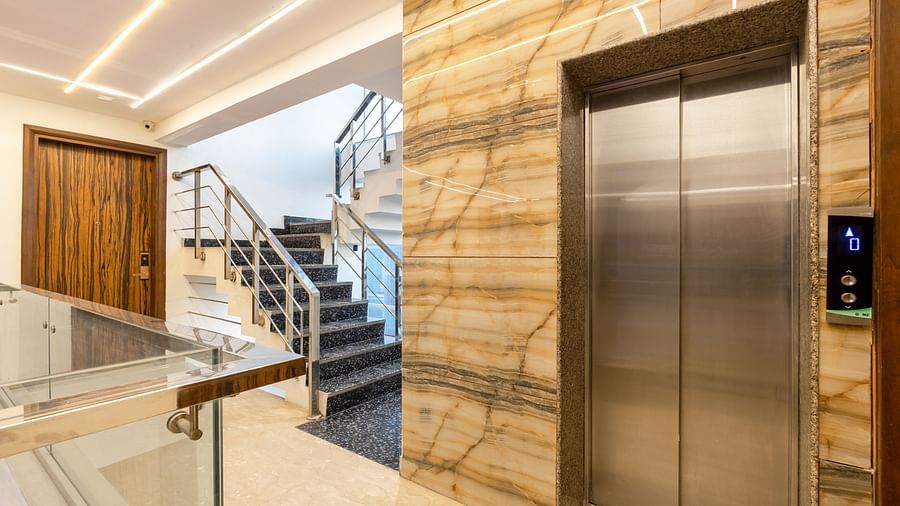 Hotel corridor with an elevator and staircase at Hotel Bawa, Gurgaon.
