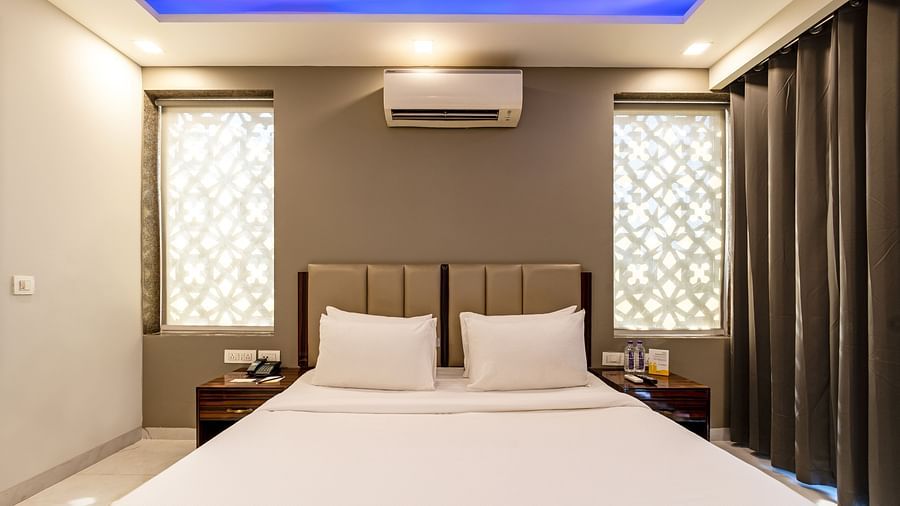 A hotel room with ambient lighting and a wall-mounted split A/C at Hotel Bawa, Gurgaon.