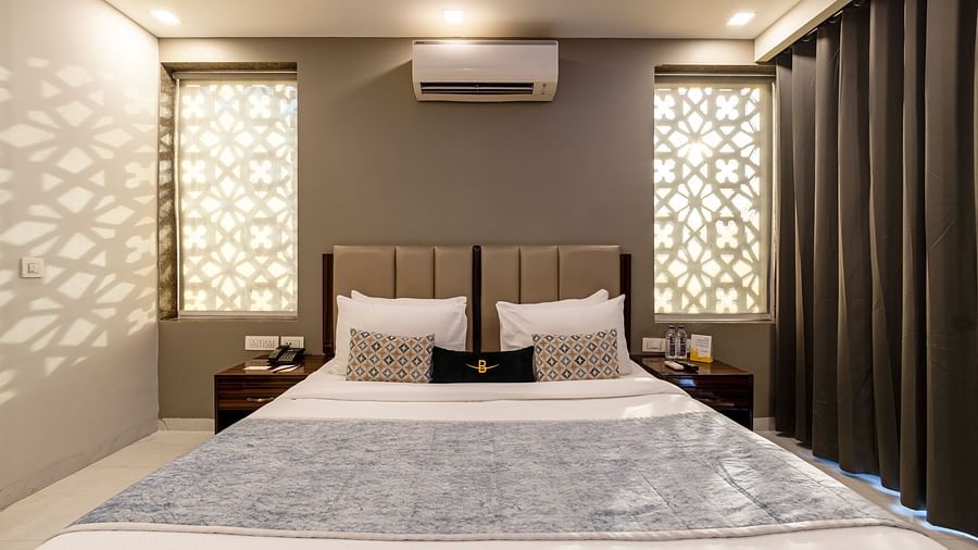 A hotel room with a king size bed, soft lighting, and modern decor at Hotel Bawa, Gurgaon.