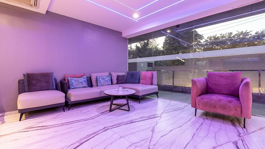 Lounge area with plush sofas and large glass windows at Hotel Bawa, Gurgaon.