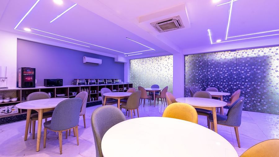 Dining area with ambient purple lighting where chairs and tables are placed | Hotel Bawa, Gurgaon.