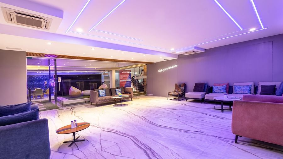 Brightly-lit lounge with comfortable sofas and modern interior design at Hotel Bawa, Gurgaon.