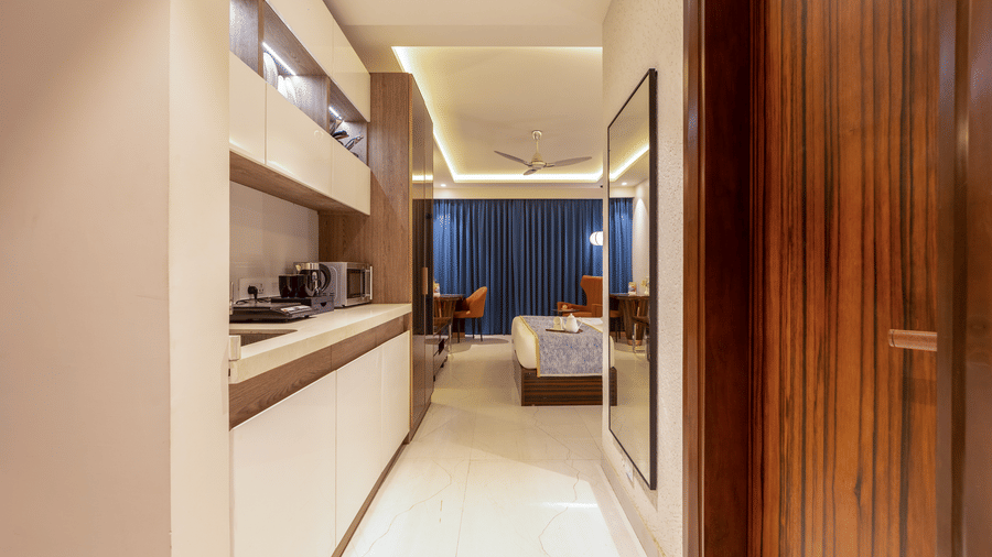 Perspective view from the hallway of a premium studio showing the kitchen and living area.