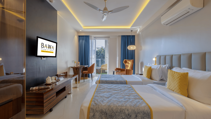 Wide-angle shot of a premium twin-bed hotel room with contemporary decor and soft lighting.