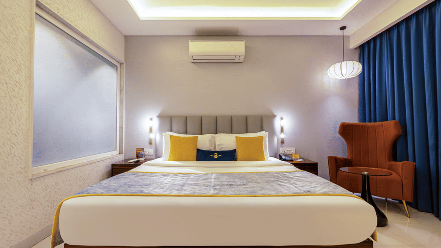 Comprehensive view of a standard suite showing the bed, seating area, and television unit.