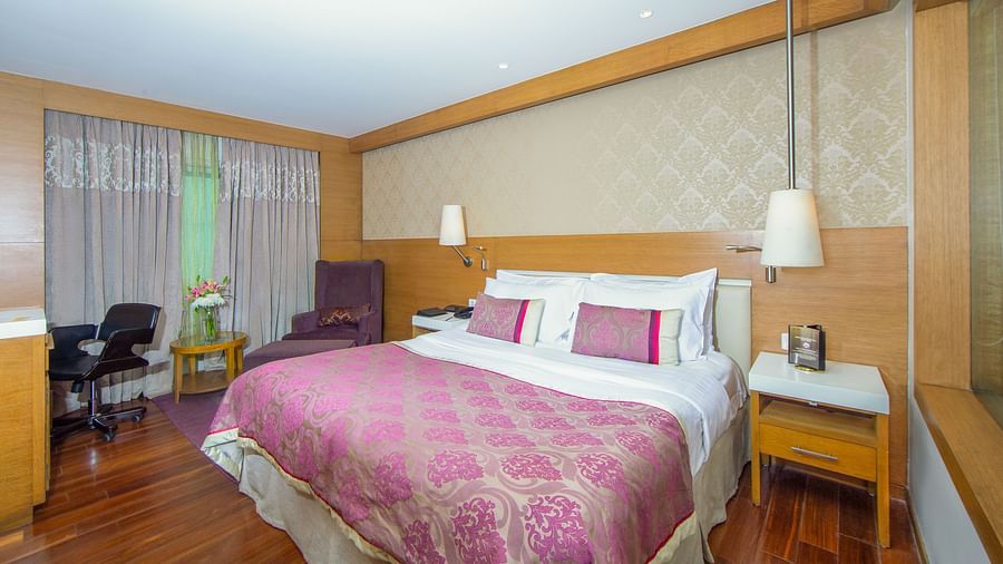 room with king size bed and wooden flooring at hotel bawa international
