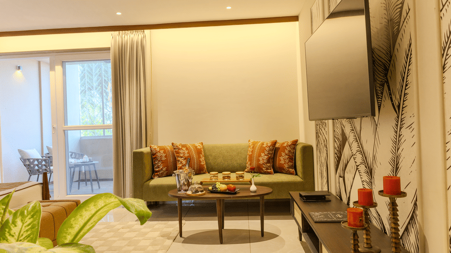 Living area with a cushioned sofa, wooden coffee table and decorative elements in the Imperial Suite at Hotel Bawa, Udaipur.