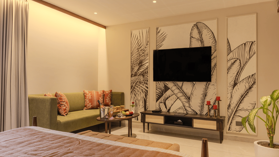 Bright living room with a cushioned sofa, indoor plants and botanical wall art in the  Suite at Hotel Bawa, Udaipur