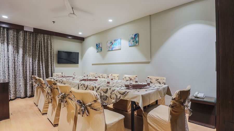 A cosy and well-decorated banquet-style setup with neatly arranged chairs, tables, and vibrant wall art, ideal for intimate gatherings or small meetings.