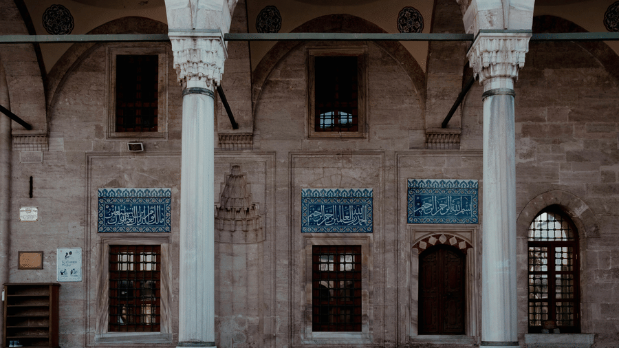 Alamgir Mosque with stone façade, arched entrances, and symmetrical Mughal-style design.