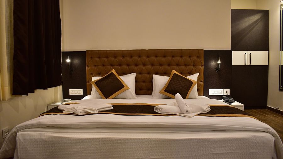 a luxury king size bed with white linens and brown pillows at Kanchenjunga View Executive Suite - hotel montana vyoo