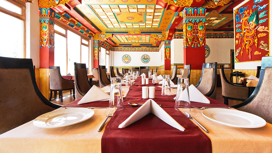 A dining area with tables and chairs placed around it at Hotel Singge Palace.