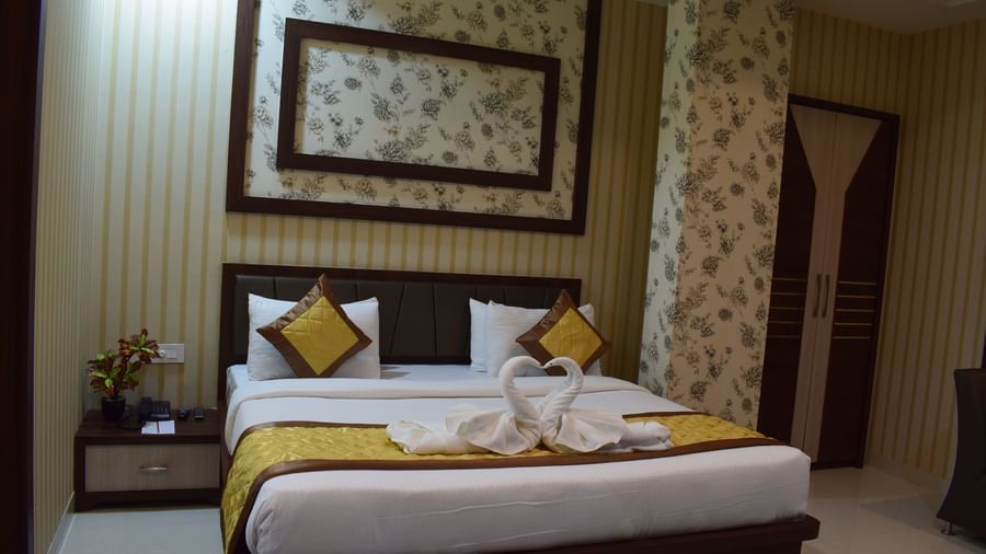 A well-furnished room with modern decor and elegant bedding at Hotel Uday Palace, one of the top hotels near Kashi Vishwanath Temple.