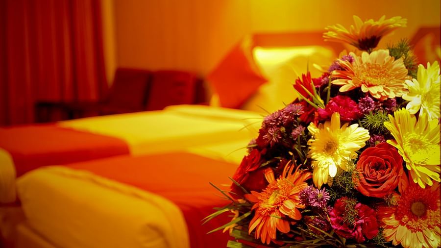  Hotel Yasodha Towers - Shallow depth of field closeup shot of a bouquet of flowers with a double bed in the background
