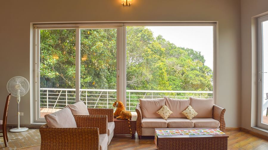 Indoor lounge with sofa, cosy setting, warm lighting, and wooden flooring at Ibex Resorts, Coonoor (Tapas).