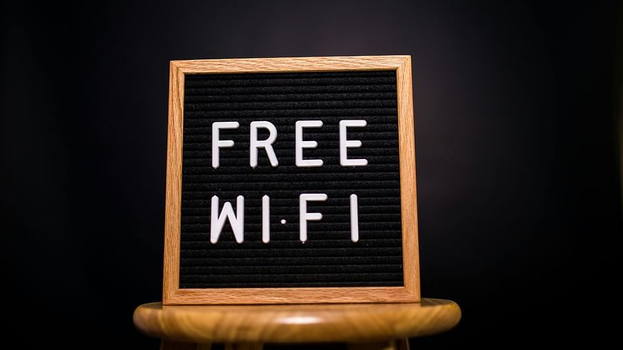 A wooden-framed letter board displays FREE WI-FI in white letters, set against a dark background.