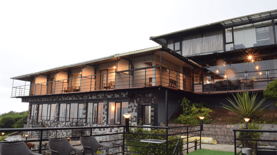 An exterior shot of the resort featuring some chairs on the private deck | Ibex Stays and Trails