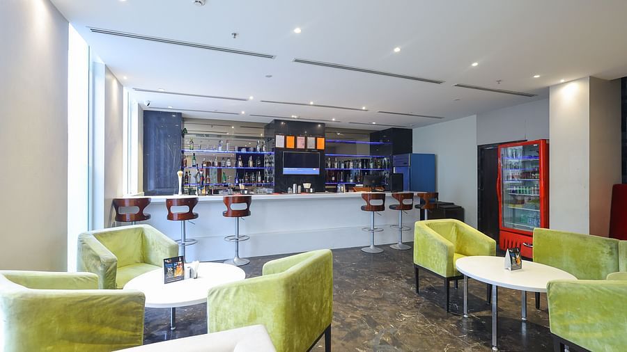 Front view of black velvet bar counter area with seating at Icon Premier Hotel by Bhagini, Devarabisanahalli